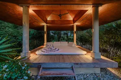 a bed under a gazebo on a wooden deck at Peaceful Retreat at Villa Langkah Luan, Mai Khao in Mai Khao Beach