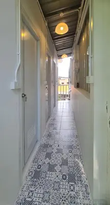 a hallway with a white and black tile floor at Sleep On The Clouds in Ban Kata