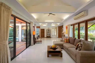 a living room with a couch and a table at Sea Breeze Pool Villa on Quiet Kamala Cul de sac in Kamala Beach