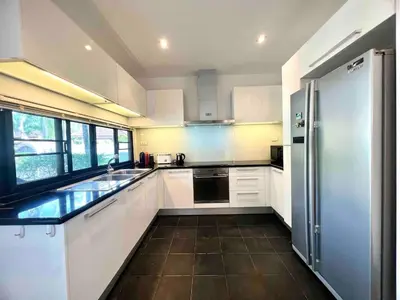 a kitchen with white cabinets and a stainless steel refrigerator at Sea Breeze Pool Villa on Quiet Kamala Cul de sac in Kamala Beach