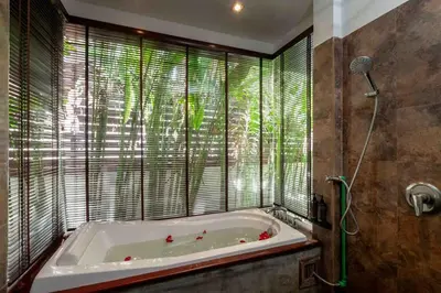 a bath tub in a bathroom with a window at Sea Breeze Pool Villa on Quiet Kamala Cul de sac in Kamala Beach