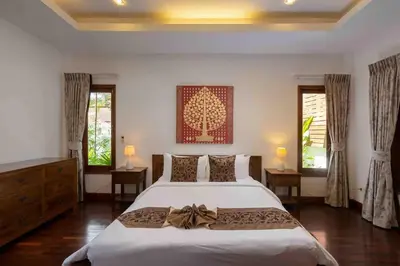 a bedroom with a large white bed and two windows at Sea Breeze Pool Villa on Quiet Kamala Cul de sac in Kamala Beach