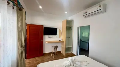 a room with a bed and a red door and a desk at Vida House Krabi, Ao Nang Beach in Ban Khlong Haeng