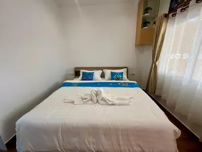a bedroom with a white bed with a bow on it at Vida House Krabi, Ao Nang Beach in Ban Khlong Haeng