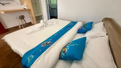 a bed with blue and white sheets and blue pillows at Vida House Krabi, Ao Nang Beach in Ban Khlong Haeng