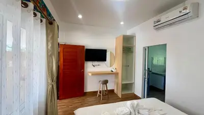 a bedroom with a red door and a desk and a bed at Vida House Krabi, Ao Nang Beach in Ban Khlong Haeng