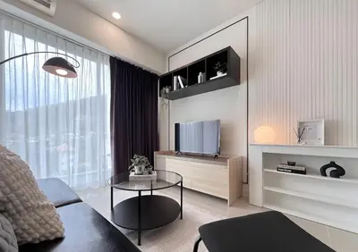 a living room with a couch and a television at CHIC CONDO - Cozy studio with mountain and sea views in Karon Beach