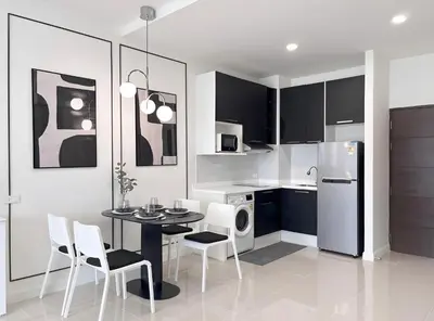 a kitchen with a table and chairs and a refrigerator at CHIC CONDO - Cozy studio with mountain and sea views in Karon Beach