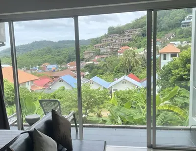 a view from the living room window of a house at CHIC CONDO - Cozy studio with mountain and sea views in Karon Beach