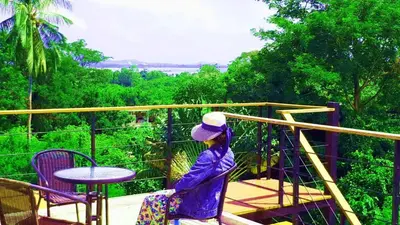 a woman is standing on a balcony at Jasmine Seaview 'B' Friendly Guest House in Ban Saiyuan (1)