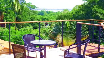 a patio with a table and chairs on a balcony at Jasmine Seaview 'C' Friendly Guest House in Ban Saiyuan (1)
