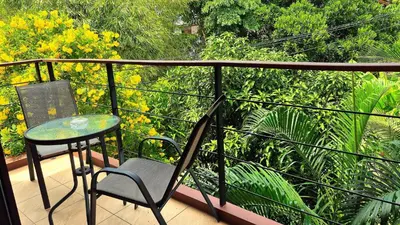 a balcony with a table and a chair and trees at Jasmine Seaview 'C' Friendly Guest House in Ban Saiyuan (1)