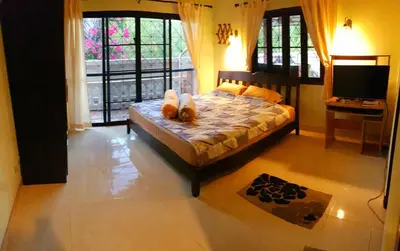 a bedroom with a bed with a teddy bear on it at Jasmine's Bungalow 3 bedroom 2 bathrooms Baby Cots in Ban Saiyuan (1)