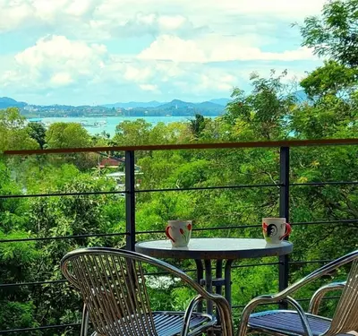 a table and chairs on a balcony with a view at Jasmine Ocean View Penthouse in Ban Saiyuan (1)