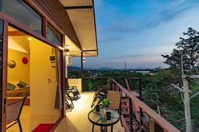 a room with a balcony with a table and chairs at Jasmine Ocean View Penthouse in Ban Saiyuan (1)