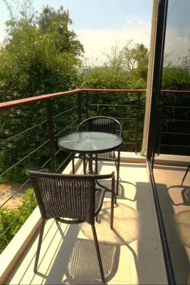 a patio with a table and chairs on a balcony at Jasmine Seaview 'A1' Friendly Guesthouse in Ban Saiyuan (1)