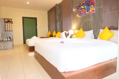 a hotel room with two beds with yellow and white pillows at The Meeting House Aonang - self service in Ao Nang Beach
