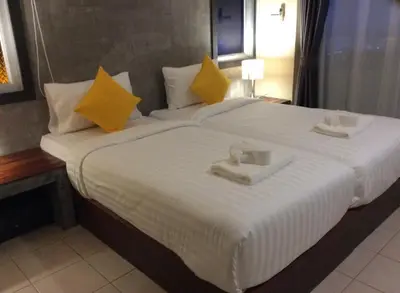 a large white bed with two trays on it at The Meeting House Aonang - self service in Ao Nang Beach
