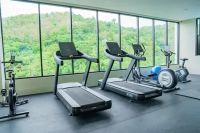a gym with a bunch of exercise bikes in a room at A Taste of Utopia -Modern Phuket Retreat with Jacuzzi in Karon Beach