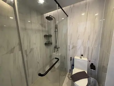 a bathroom with a shower with a toilet and a glass door at A Taste of Utopia -Modern Phuket Retreat with Jacuzzi in Karon Beach