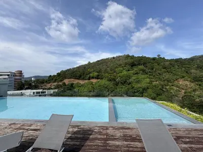 a swimming pool with a mountain in the background at A Taste of Utopia -Modern Phuket Retreat with Jacuzzi in Karon Beach