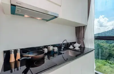 a kitchen with a sink and a stove with a window at The Viva Patong Condo in Patong Beach