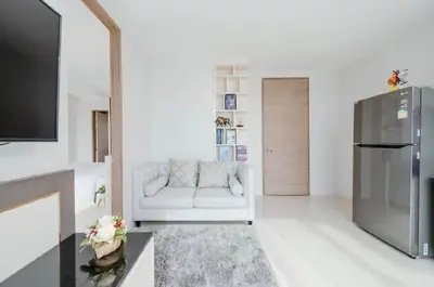 a living room with a white couch and a refrigerator at The Viva Patong Condo in Patong Beach