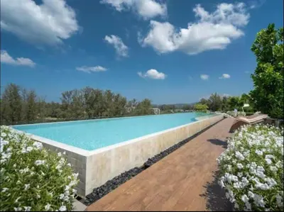 a large swimming pool in a yard with flowers at Laguna SkyPark in Laguna Phuket