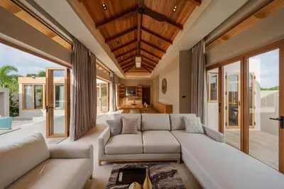 a living room with a large couch and windows at Celestia Villas - Pool villa 4BR near Boat Avenue in Ban Pak Lak