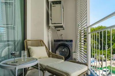 a balcony with a table and a washing machine at Title Halo Lemon Sky Naiyang Gym Pool Hammam in Ban Bo Han
