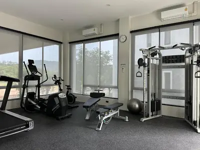 a gym with treadmills and exercise equipment and windows at Title Halo Lemon Sky Naiyang Gym Pool Hammam in Ban Bo Han