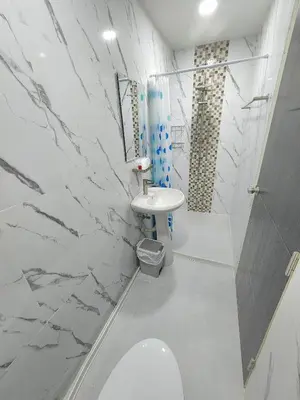 a white bathroom with a toilet and a sink at Raya villa in Ban Muang Mai