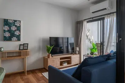 a living room with a blue couch and a tv at Title Halo Pinky Lime Naiyang Pool Gym Hammam in Ban Bo Han
