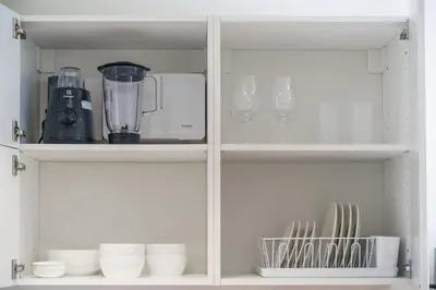 a white cabinet with dishes and a blender on it at Title Halo Pinky Lime Naiyang Pool Gym Hammam in Ban Bo Han