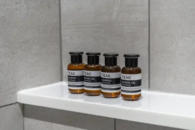 three bottles of honey sitting on a shelf in a bathroom at Title Halo Pinky Lime Naiyang Pool Gym Hammam in Ban Bo Han