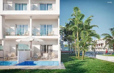 an apartment building with a swimming pool and palm trees at Hotel Riu Palace Phuket - All Inclusive in Mai Khao Beach