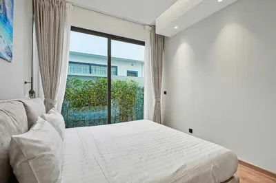 a bedroom with a bed and a large window at C32 Clover Residence Villa Phuket 3 bd in Ban Thalat Choeng Thale