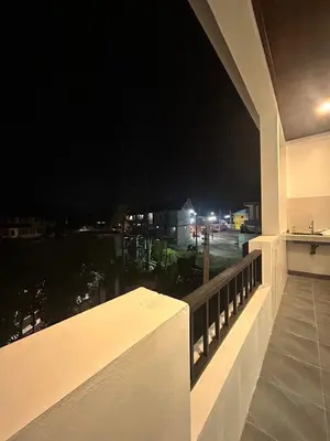 a balcony with a view of a parking lot at night at The Hidden Place Bangtao in Ban Thalat Choeng Thale