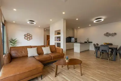 a living room with a brown couch and a table at Modern and Peaceful 3Bedroom Villa Family Retreat Rawai in Ban Saiyuan (1)