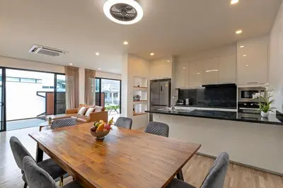 a kitchen and dining room with a wooden table and chairs at Modern and Peaceful 3Bedroom Villa Family Retreat Rawai in Ban Saiyuan (1)