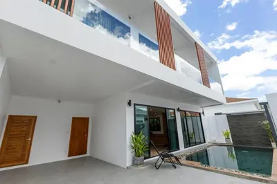 a white house with a swimming pool and a balcony at Modern and Peaceful 3Bedroom Villa Family Retreat Rawai in Ban Saiyuan (1)
