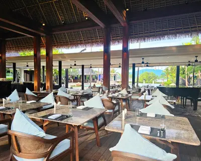 a restaurant with tables and chairs and a grand piano at BB Luxury Villa in Phuket Town