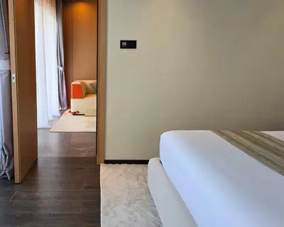 a bedroom with a bed and a hallway with a chair at BB Luxury Villa in Phuket Town