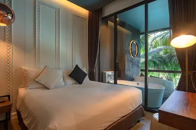 a bedroom with a bed and a balcony with a tub at Saturdays Residence by Sure in Ban Saiyuan (1)
