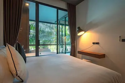 a bedroom with a large bed and a large window at Saturdays Residence by Sure in Ban Saiyuan (1)