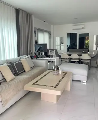 a living room with a couch and a table at Spacious Modern Home & Garden Perfect for Families in Ban Na Nai
