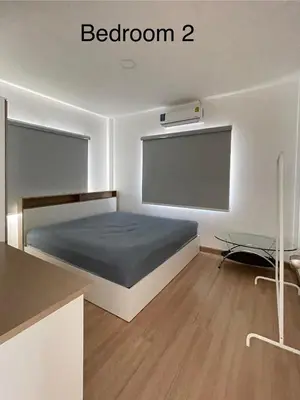 a bedroom with a bed and a table in it at Spacious Modern Home & Garden Perfect for Families in Ban Na Nai