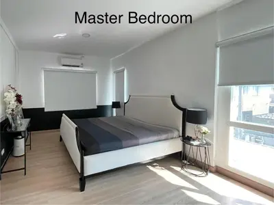 a bedroom with a bed and a chalkboard on the wall at Spacious Modern Home & Garden Perfect for Families in Ban Na Nai