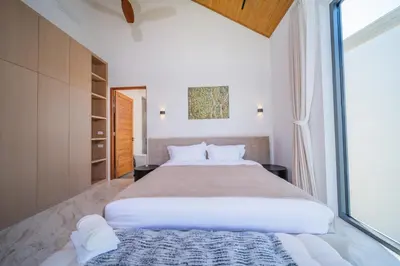 a bedroom with a large bed and a large window at \u9760\u8fd1\u5e2e\u6d9b\u6d77\u6ee9\u56db\u5367\u5ba4\u5bb6\u5ead\u522b\u5885 in Ban Lum Fuang