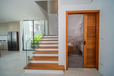 a staircase in a house with a glass door at \u9760\u8fd1\u5e2e\u6d9b\u6d77\u6ee9\u56db\u5367\u5ba4\u5bb6\u5ead\u522b\u5885 in Ban Lum Fuang